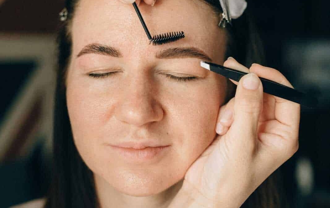 Estetista che applica extension ciglia su una donna con occhi chiusi, procedimento di lash extension, bellezza naturale, cura del viso, estetica professionale.