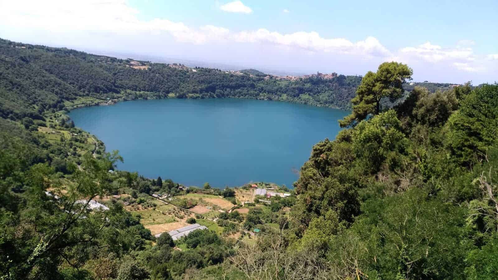 Lago di Montagna immerso nella natura verde, con colline e boschi circostanti, vista panoramica di un sito naturale in un contesto tranquillo e pittoresco in Italia.