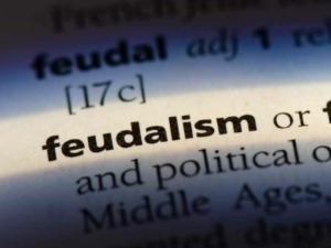 Feudalism definizione e caratteri principali esposti in un dizionario storico e politico, con enfasi sul Medioevo.