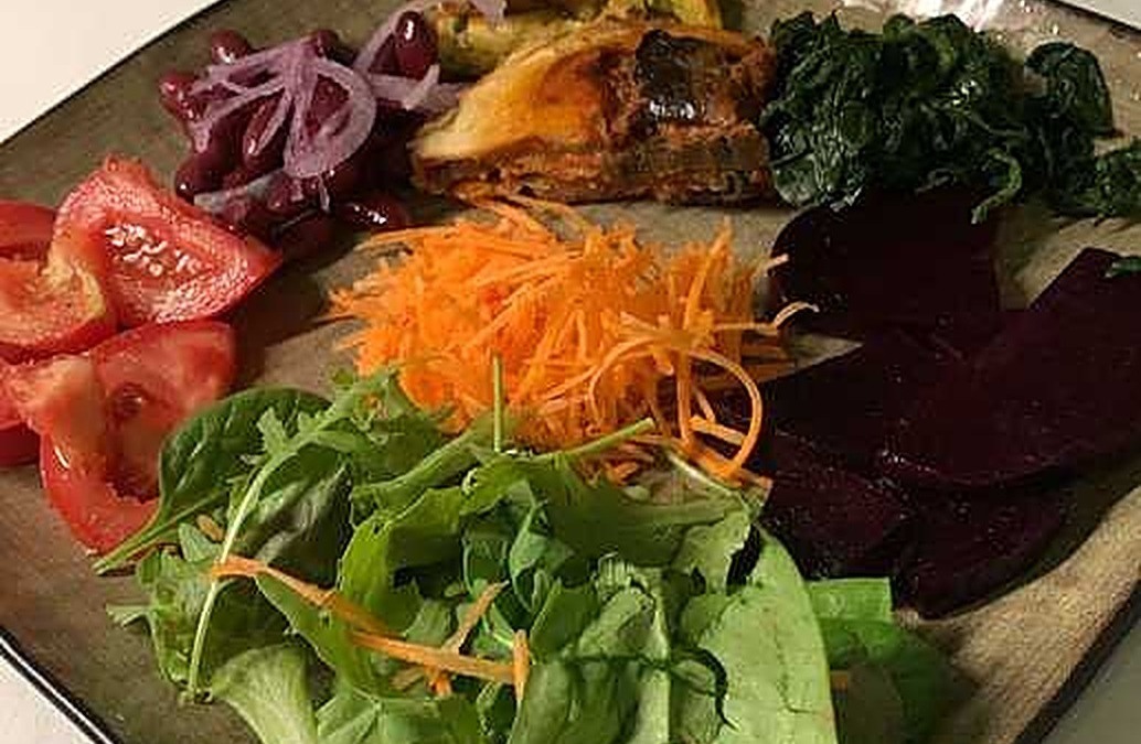 Verdure miste e insalata fresca con pomodori, carote, barbabietole, spinaci e rucola, servite in un piatto elegante, perfette per un pasto leggero e salutare in stile blog gastronomico.