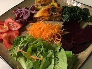 Verdure miste e insalata fresca con pomodori, carote, barbabietole, spinaci e rucola, servite in un piatto elegante, perfette per un pasto leggero e salutare in stile blog gastronomico.