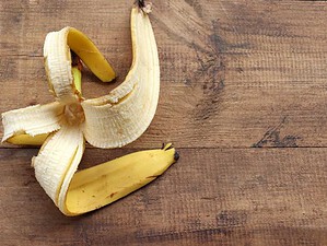 Banana sbucciata e divisa in pezzi su superficie di legno rustico, alimenti salutari e snack naturali, immagine di frutta fresca per ricette e benessere.