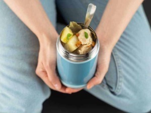 Untitled Image of homemade stew with vegetables in a jar held by a person in casual jeans, highlighting healthy comfort food suitable for blog content.