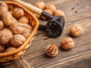 Mandorle nel guscio con schiaccianoci su tavolo di legno rustico, snack naturale salutare, fonte di proteine e nutrienti, ideali per una dieta sana, preparazione di dolci e ricette healthy.