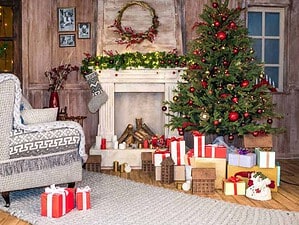 Albero di Natale decorato con palline rosse e dorate, regalo di Natale avvolti in carta colorata sotto la decorazione natalizia in stile rustic con camino acceso e arredamento festivo.