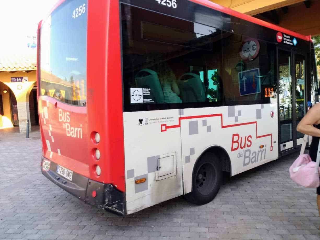 Autobus rosso e bianco con logo "Bus del Barri" a Madrid, arredamento urbano, servizio di trasporto pubblico.