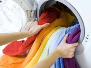 Lavatrice con asciugamani colorati in lavaggio, cura dei tessuti, biancheria colorata, lavaggio a casa, pulizia e cura degli asciugamani di cotone.