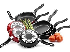 Pentole antiaderenti con manici neri, asparagi freschi e pomodori, ideali per cucinare ricette semplici e salutari, perfette per la cucina moderna e funzionale.