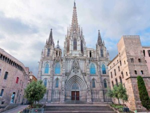 Maestosa vista della Cattedrale di Girona con dettagli gotici e rosone centrale sotto un cielo nuvoloso.