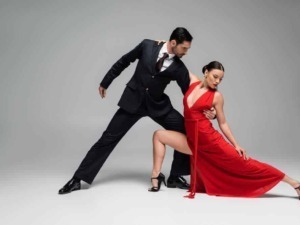 Elegant dance couple in formal attire performing tango, showcasing passion, rhythm, and precision in a studio setting, ideal for content related to dance, passion, and elegance.