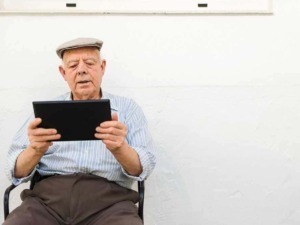 Vecchio uomo che usa tablet, digitalizzazione anziani, tecnologia senior, persone anziane con dispositivo digitale, innovazione digitale per anziani.