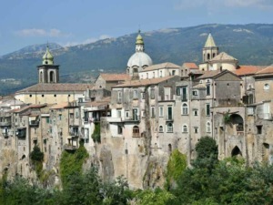 Ville storiche costruite su scoscese scogliere, con case in pietra e tetti in terracotta, immersa nel verde e con una suggestiva vista sulle montagne, simbolo di bellezza e storia italiana.