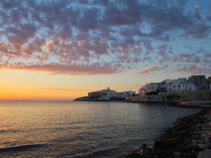 Tramonto sulla costa di Apulia con cielo colorato e paesaggio marittimo.