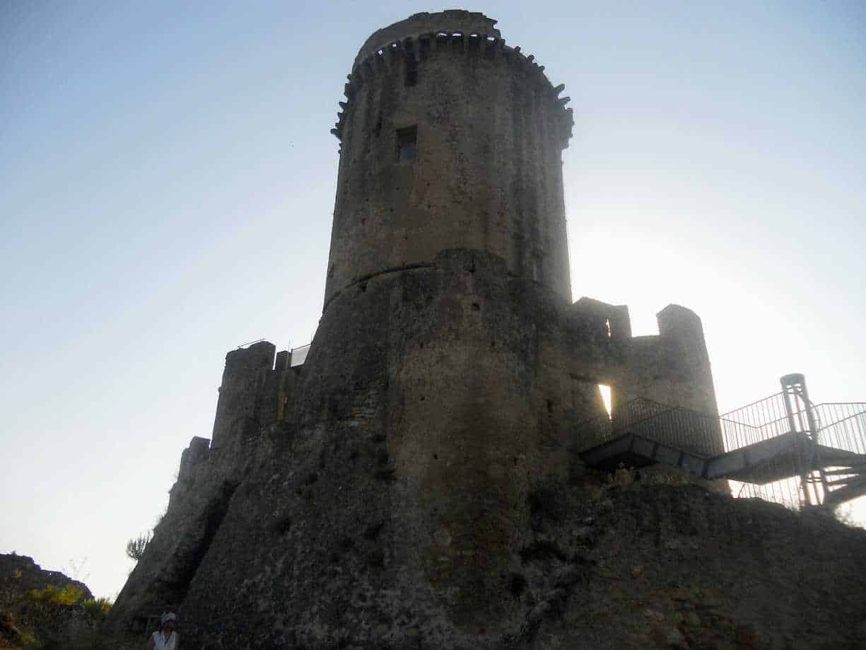 Torre medievale in pietra con vista al tramonto, castello storico e monumento antico, destinazione turistica in Italia.