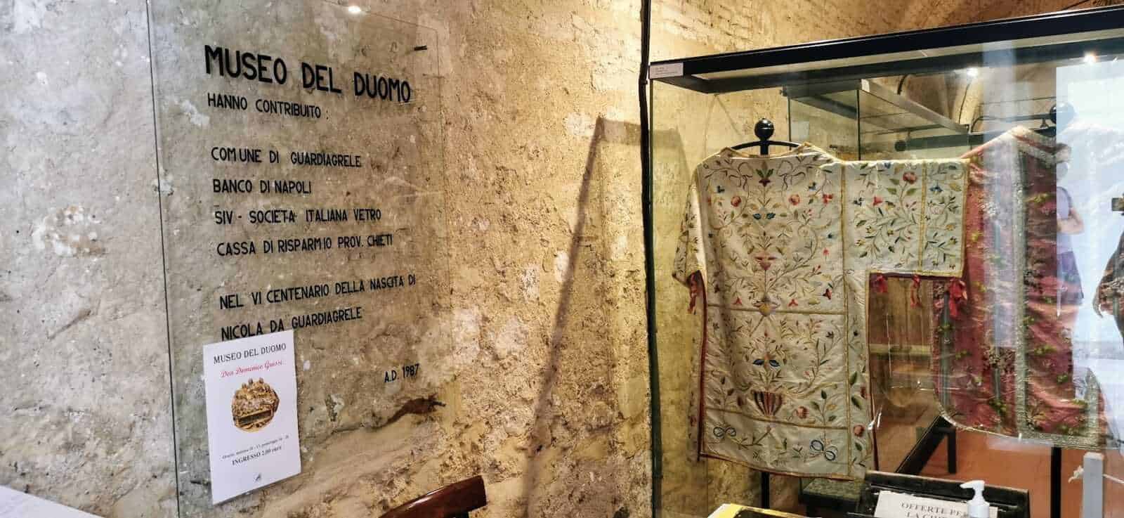 Antico vestito ricamato esposto nel Museo del Duomo a Napoli, simbolo di arte e storia religiosa, con testimonianze di contributi storici e culturali.