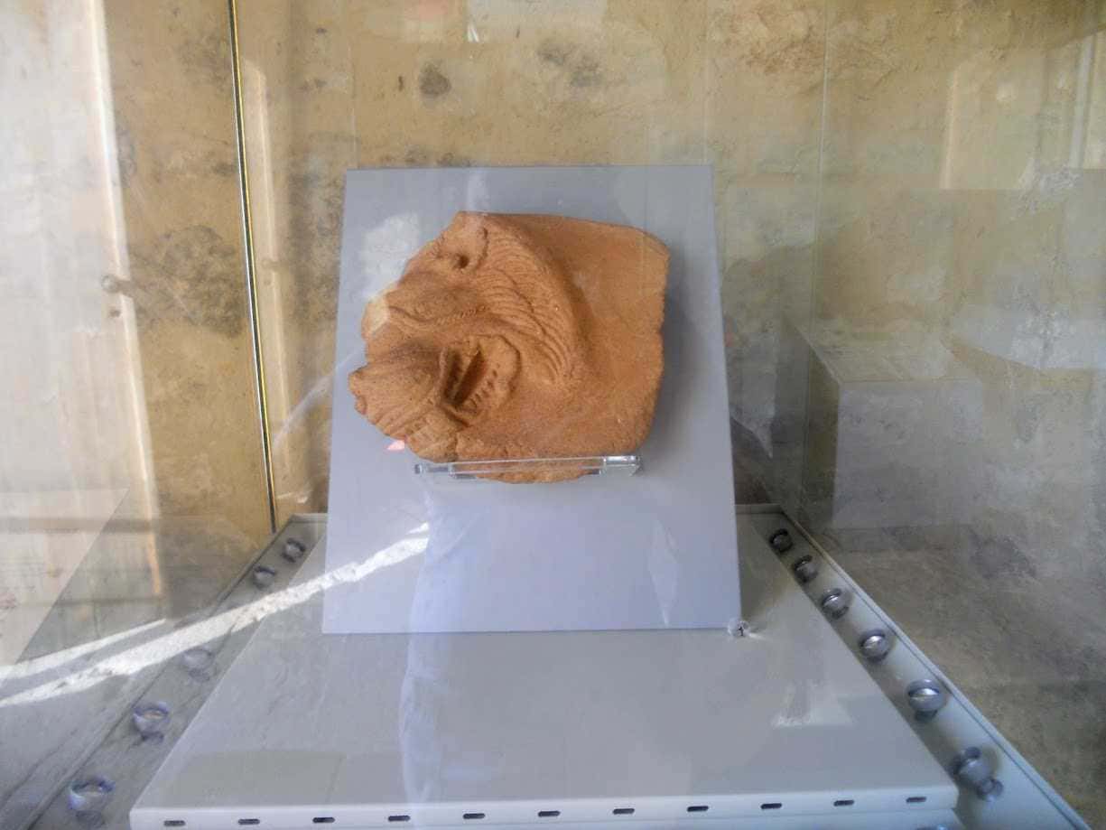 Tecnica di scultura in pietra raffigurante un leone maestoso, esposta in mostra museale con illuminazione mirata e ambiente di architettura moderna. Perfetta per appassionati di arte e sculture storiche.