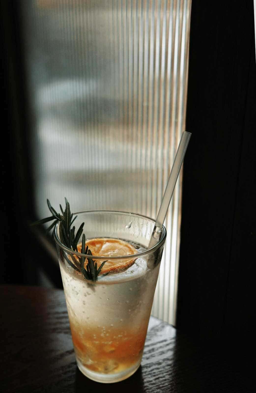 7 Benefici del tè di rosmarino a digiuno 4 Digestivo rinfrescante con limone, rosmarino e acqua frizzante in un bicchiere trasparente. Perfetto esempio di ricetta di cocktail estivi, ideale per rilassarsi e gustare un drink gustoso tra amici.