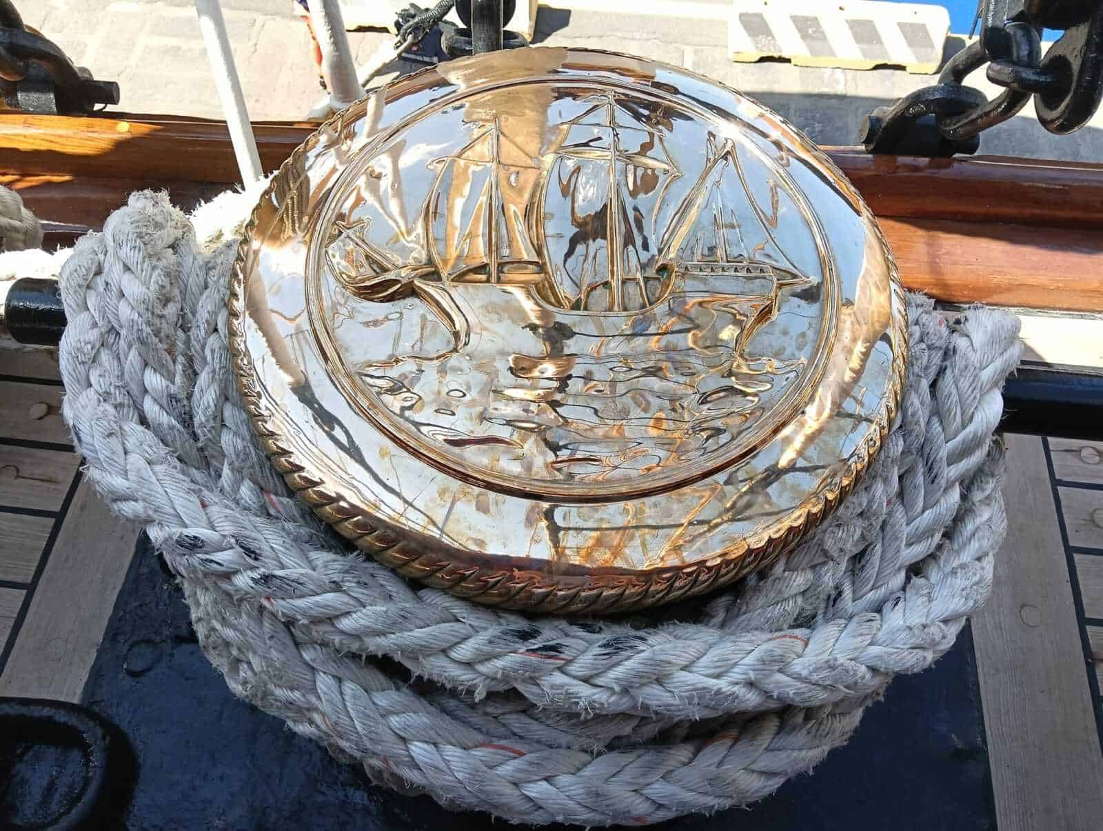 Amerigo Vespucci a Napoli 2025: cosa sapere 14 Vassoio in cristallo con nave su strada, decorazione dettagliata in rilievo, posizionato su corda di canapa intrecciata, luce naturale e sfondo urbano.