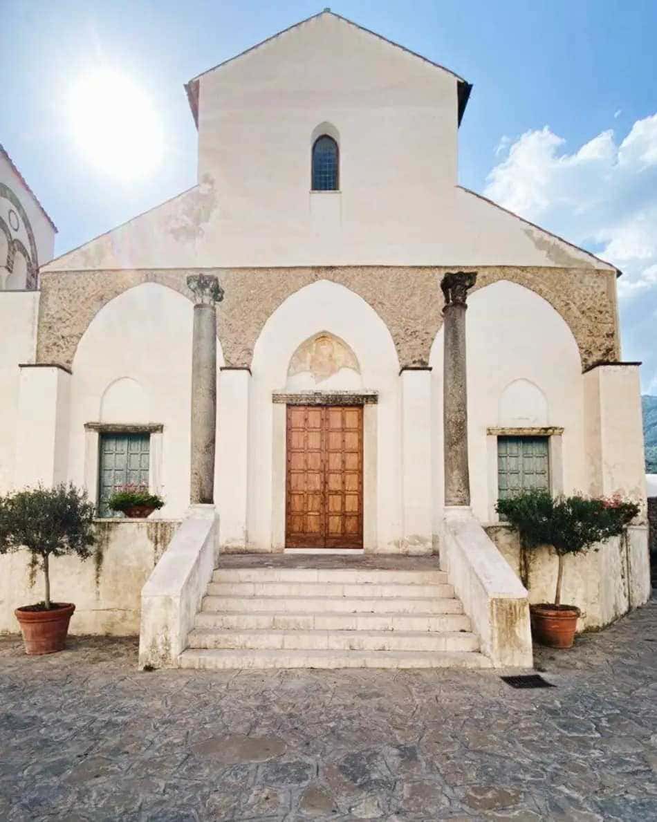 Elegante porta in legno massello con dettagli nella parte superiore e maniglione in ottone, ideale per l'ingresso di una casa moderna o tradizionale.
