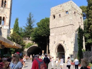Antico torre e chiesa storica a Ravello con turisti e sfondo cielo blu, famosa attrazione culturale e storica in Italia.