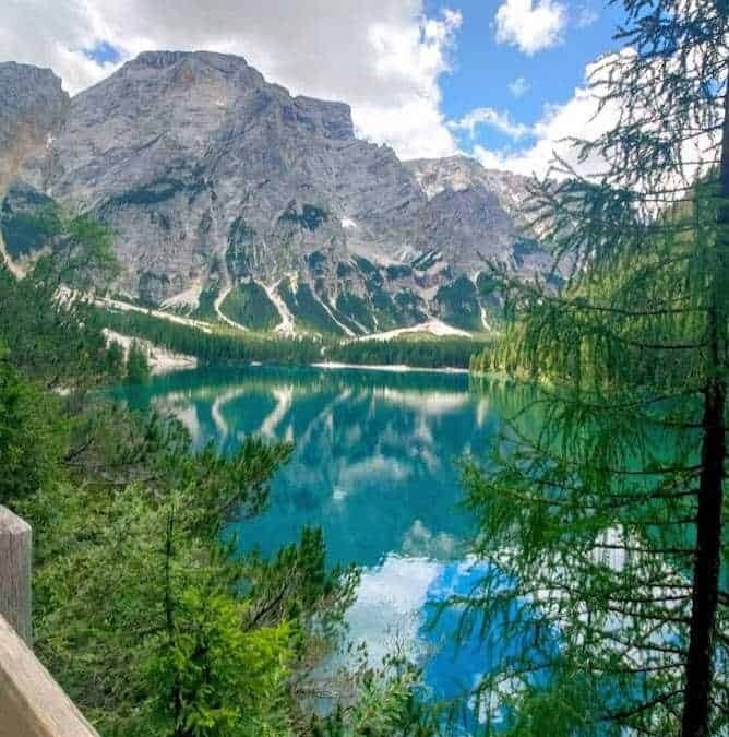 Vetta di una montagna riflessa in un lago alpino circondato da natura incontaminata e cielo nuvoloso, paesaggio mozzafiato, scenery montano, viaggio in natura, escursionismo.