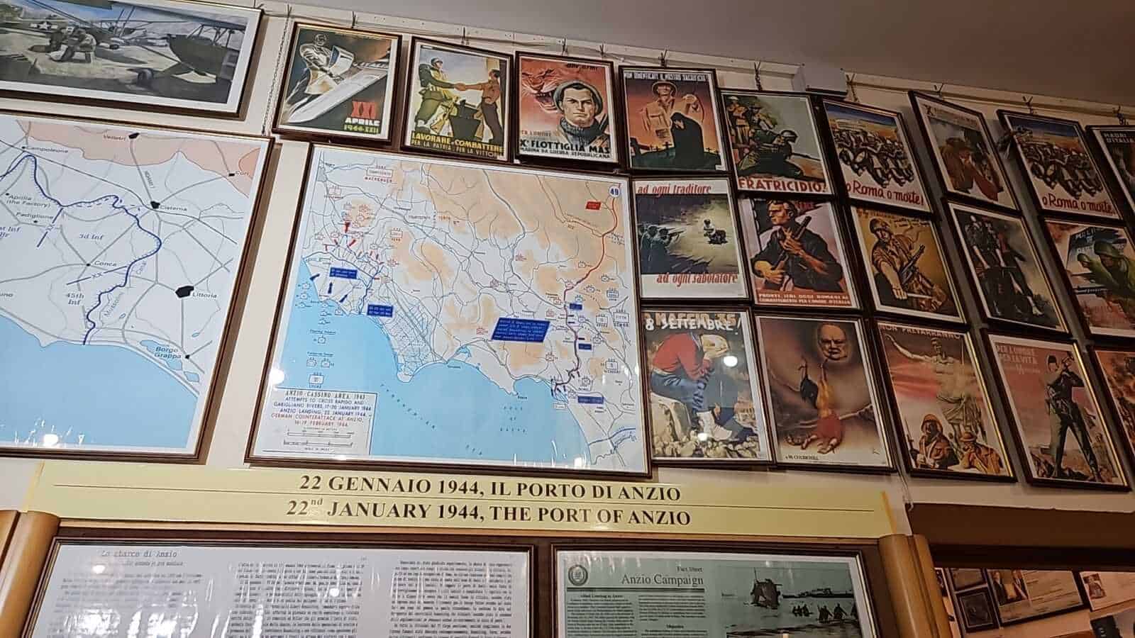 Cartina storica del porto di Anzio e poster di propaganda della Seconda Guerra Mondiale con immagini di militari e battaglie.