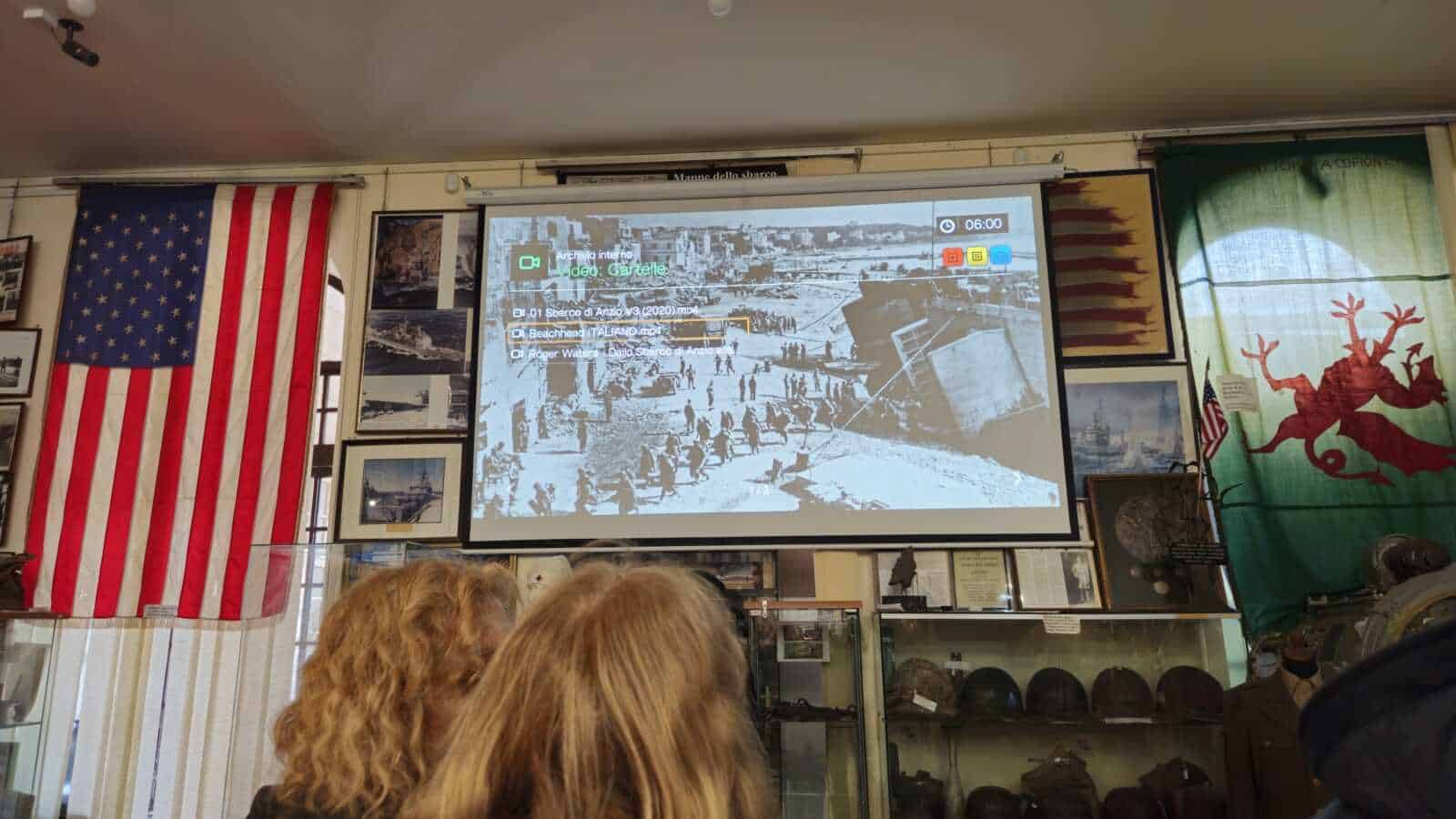 Stampa di un video archivio storico sulla spiaggia di Taranto con persone e ombrelloni.