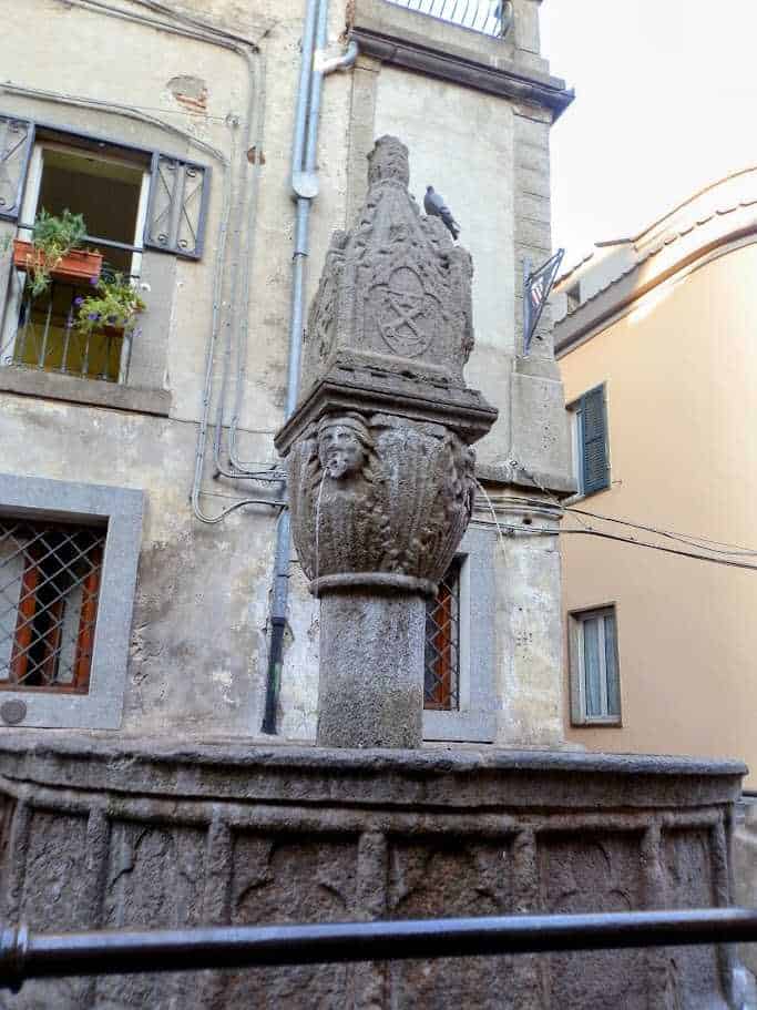 Antico fontanile in pietra con sculture di leoni