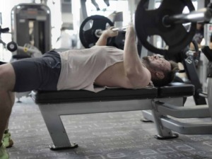 Sollevamento pesi uomo in palestra, allenamento muscolare, esercizio di sollevamento pesi, fitness e body building.