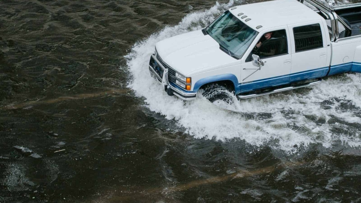 Auto pick-up su acqua con motore potente e illuminazione, scenario naturale affascinante e avventuroso.