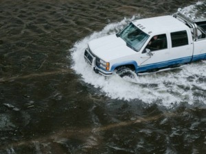 Auto pick-up su acqua con motore potente e illuminazione, scenario naturale affascinante e avventuroso.