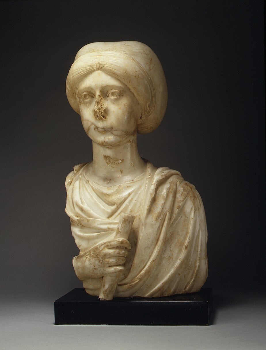 Antica scultura in marmo di una donna con volto sfigurato, simbolo di arte classica e storia antica. Perfetta per appunti sul blog dedicati all'arte, cultura e restauri.