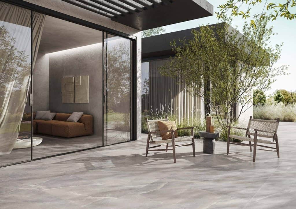 Moderno patio esterno con sedie di legno e giardino, vista sulla natura, design minimalista e arredamento elegante in stile contemporaneo. Perfetto per relax e incontri all'aperto.