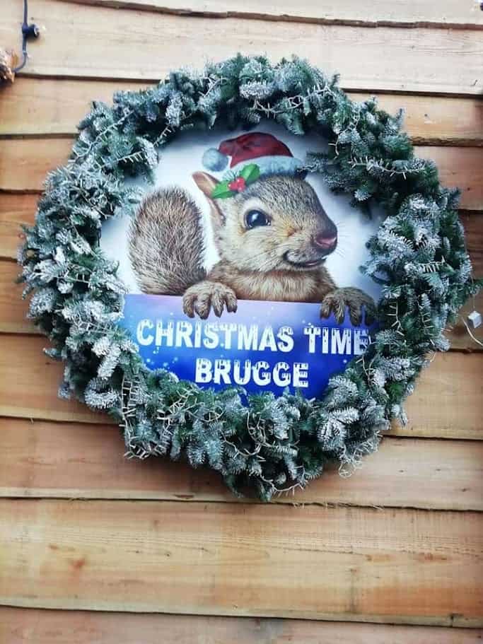 Festa di Natale con decorazione di uno scoiattolo nel cerchio natalizio, perfetta per decorare case e negozi a Brugge durante le festività natalizie.