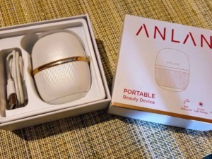 Dispositivo di bellezza portatile ANLAN con design compatto e accessori, ideale per trattamenti di cura della pelle a casa o in viaggio.
