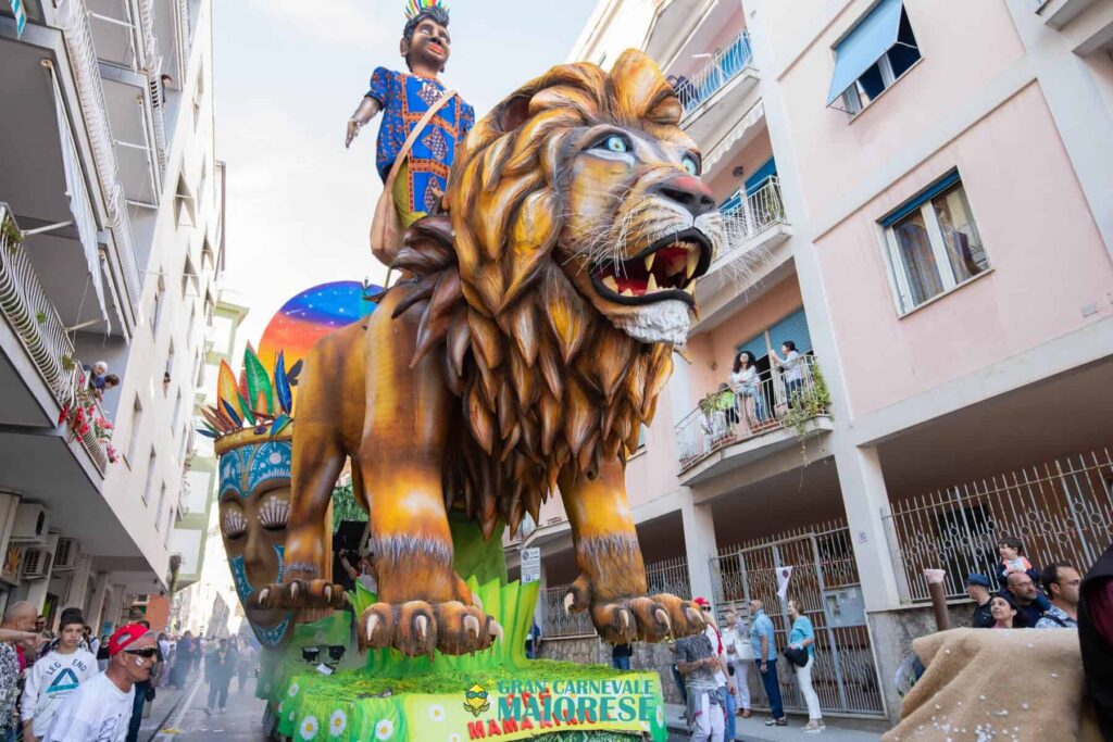 Leone di cartapesta e figurante in costume al Gran Carnevale Maiorese 2026