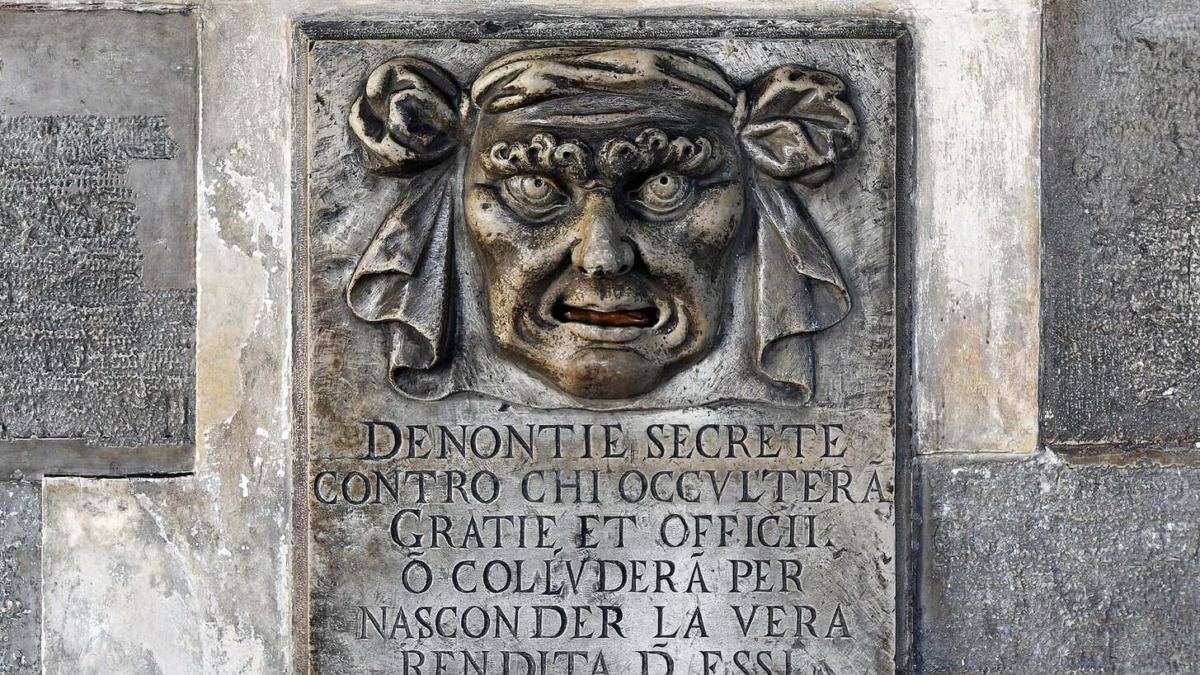 Bocca di leone a venezia: Scultura in pietra di un volto espressivo con dettagli intensi, parte di un monumento storico, simbolo di saggezza e mistero.