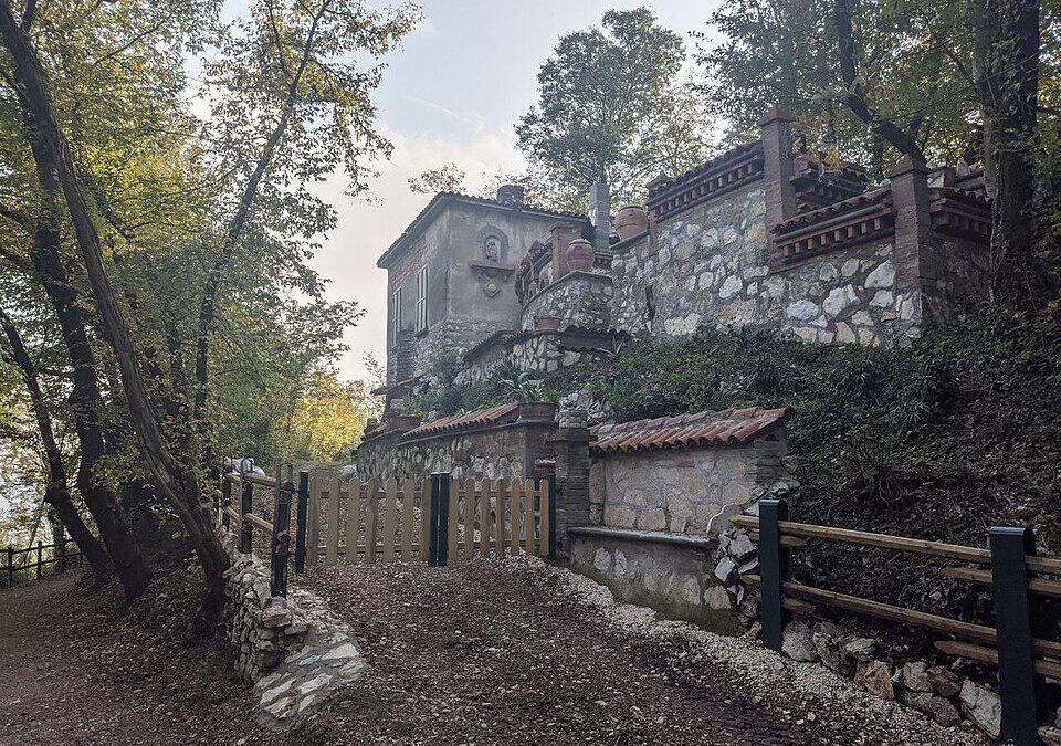 Scorcio di Monticelli Brusati in Lombardia, con sentiero e antica villa in pietra immersa nel verde, ideale per escursioni e turismo culturale.