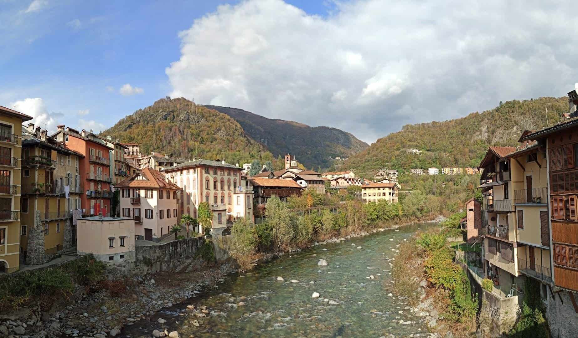 Vista panoramica di Varallo Sesia, con il fiume che attraversa il centro storico e le montagne sullo sfondo, ideale per scoprire le attrazioni imperdibili della zona.