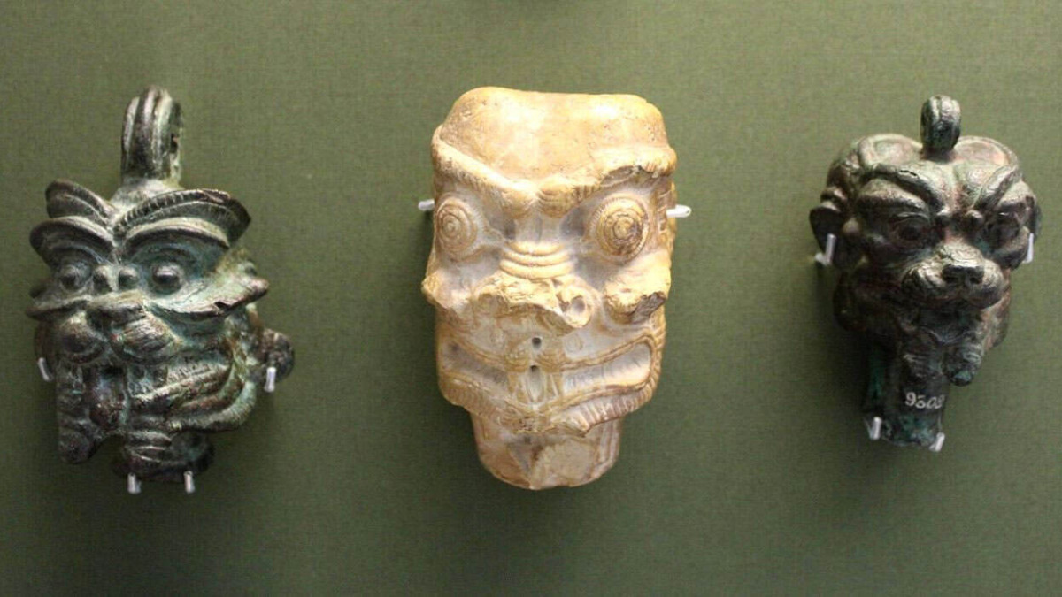 Tre maschere antiche raffiguranti Pazuzu, il demone dell'antica mitologia mesopotamica, associato a protezione e male.