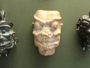 Tre maschere antiche raffiguranti Pazuzu, il demone dell'antica mitologia mesopotamica, associato a protezione e male.