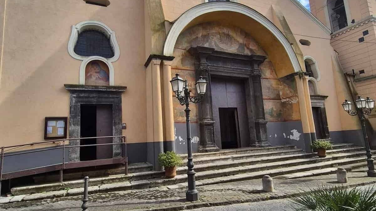 Facciata della chiesa di Sant'Egidio del Monte Albino con ingresso principale e dettagli architettonici, sotto un cielo azzurro con nuvole.