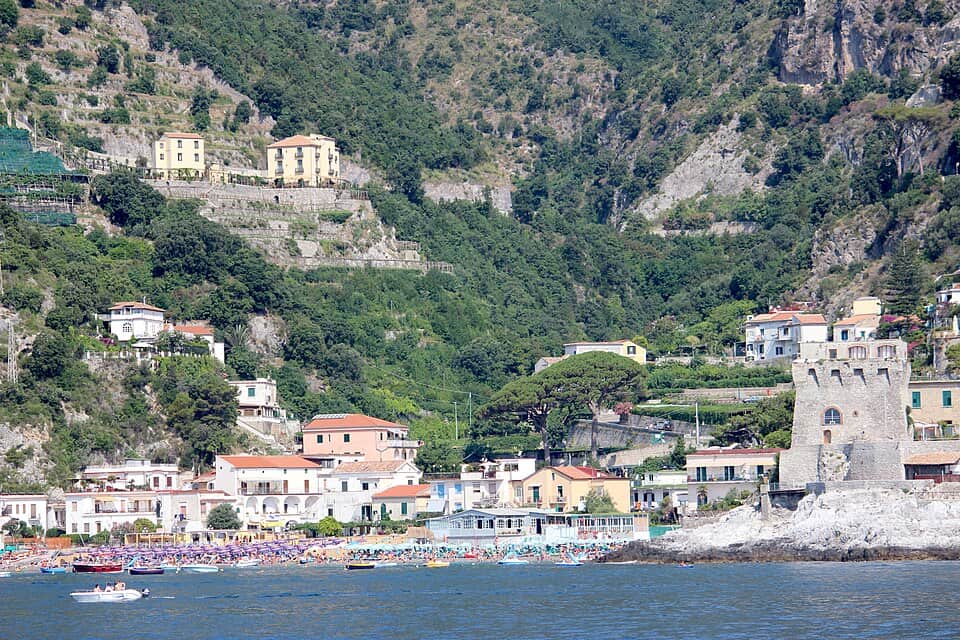 Spiaggia di Erchie con case colorate e scogliera, vista panoramica sulla Costiera Amalfitana.