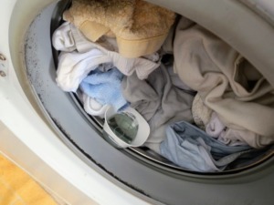 Cestello della lavatrice con il bucato e il detersivo