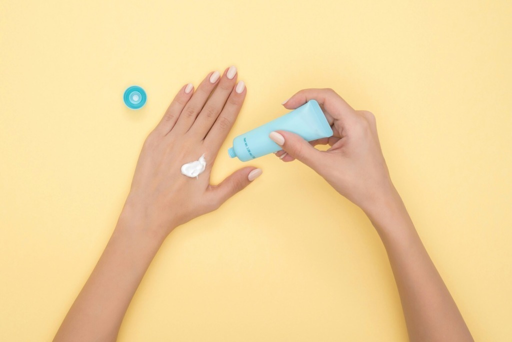 smagliature bianche, donna che applica una crema idratante